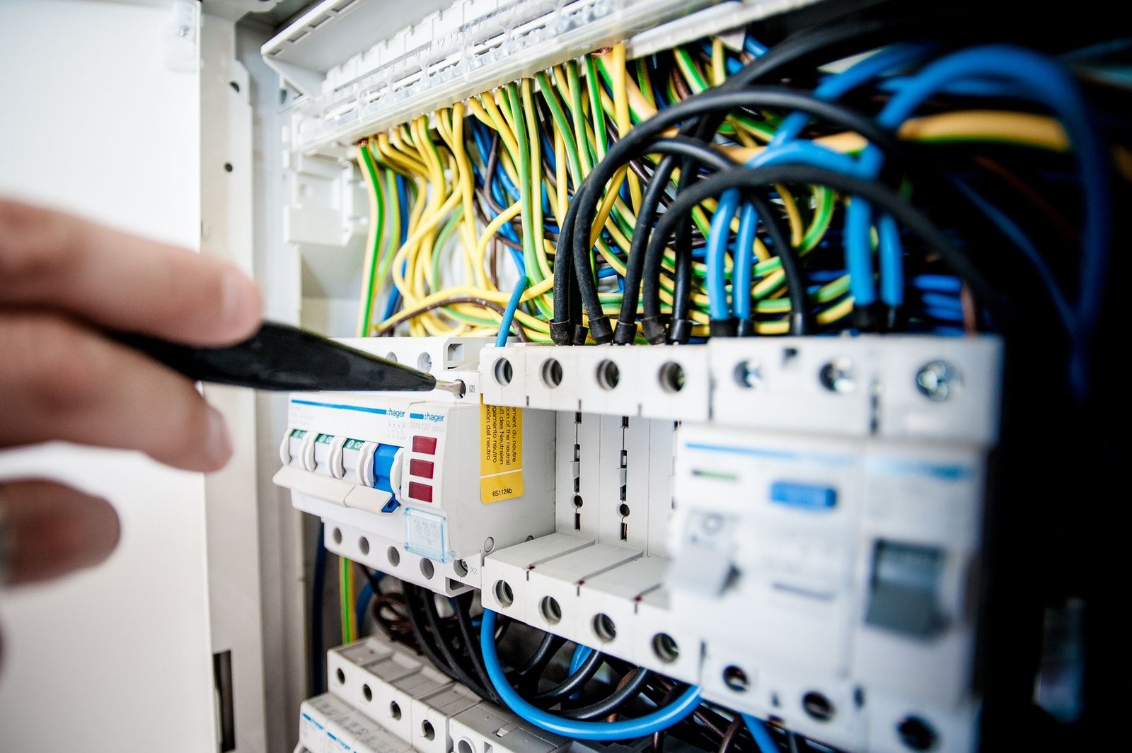 Hands working on a residential circuit breaker panel