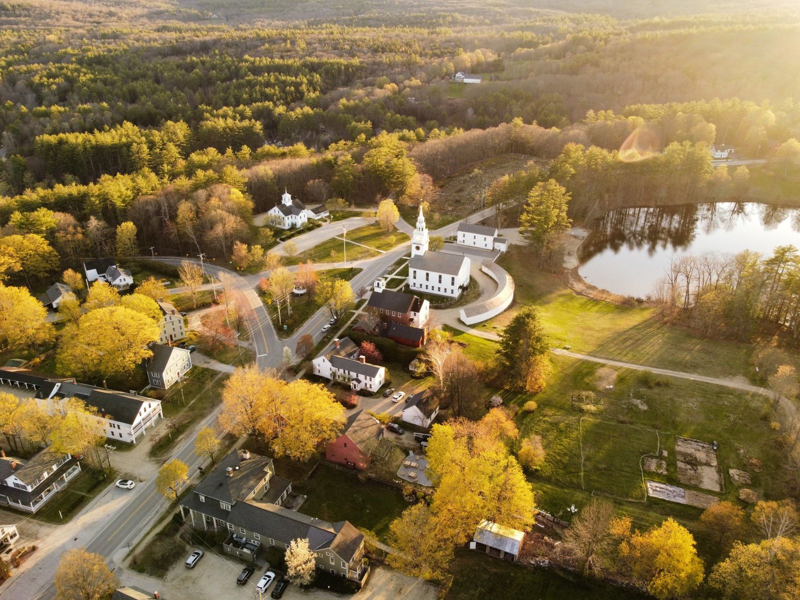 Aerial view of a New England town surrounded by fall foliage