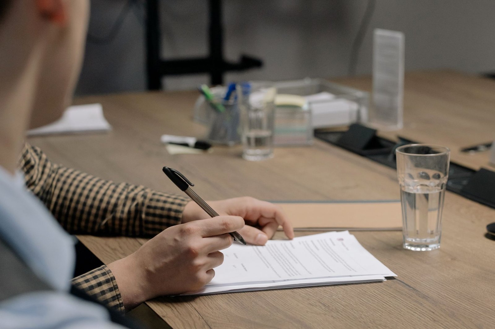 Person signing a document at a table